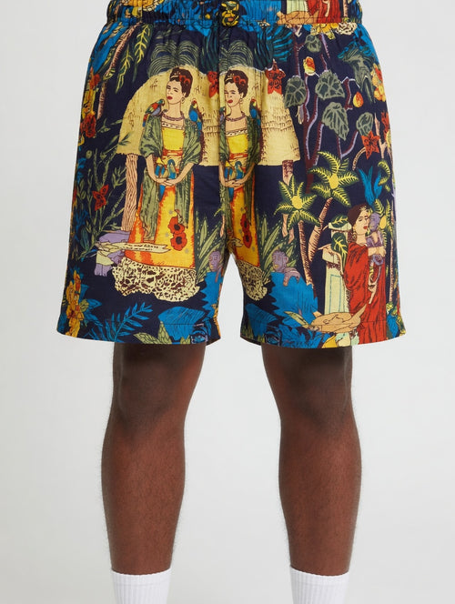 Colorful shorts with a tropical design featuring people and nature on a white background